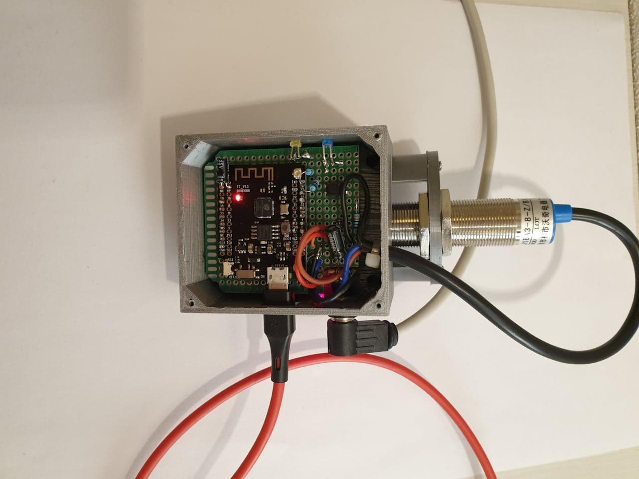 ESP32 prototype board and flow sensor mounted in a metal enclosure